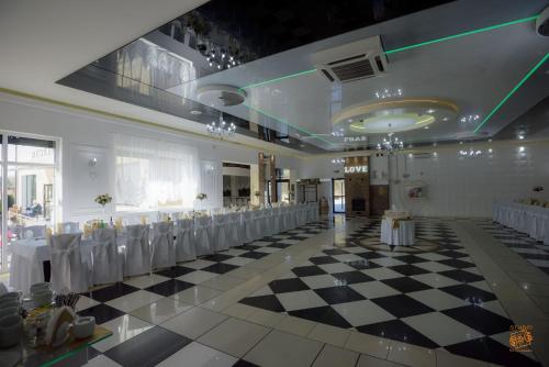 a banquet hall with a checkered floor and tables and chairs at Hotel Zajazdu w Ostrzeszowie in Ostrzeszów