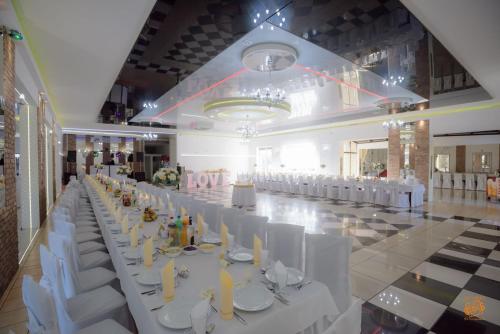 a long banquet hall with white tables and white chairs at Hotel Zajazdu w Ostrzeszowie in Ostrzeszów