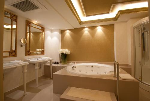 a large bathroom with a tub and two sinks at Hotel Infanta Leonor in Écija