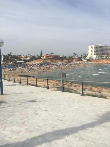 einen Strand mit einer Menschenmenge im Wasser in der Unterkunft Boulevard La Zenia Villa in Playa Flamenca