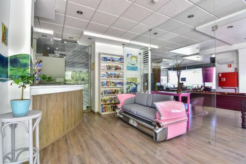 una sala de espera con una silla rosa en una tienda en Bayside Salgados en Albufeira