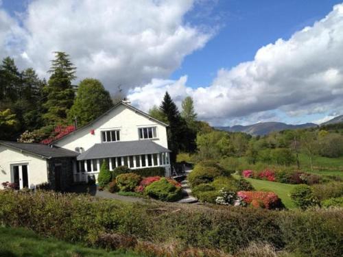 a white house with flowers in front of it at High Grassings Country House in Ambleside
