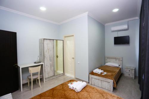 a bedroom with a bed and a mirror and a tv at Hotel City Kutaisi in Kutaisi