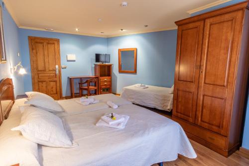 a hotel room with two beds and a tv at Hotel Peña Pandos in Felechosa