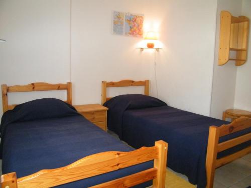 - une chambre avec 2 lits et une lampe sur le mur dans l'établissement Villa T3, 4 personnes, Le Clos du Soleil, à Narbonne-Plage