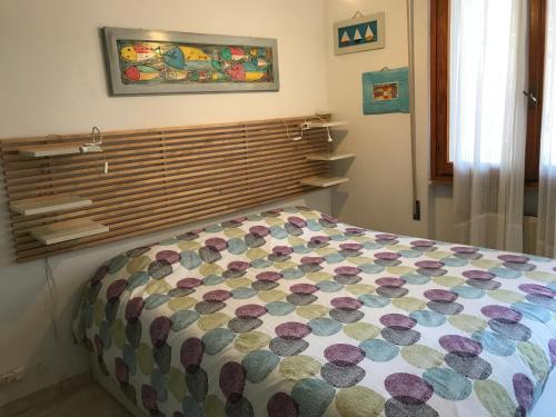 a bedroom with a bed with a colorful comforter at Il giardino dei limoni in Chiavari