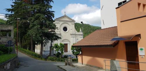 a white church with a clock tower on a building at La casa del gnocco in Masone