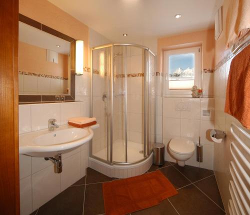 a bathroom with a shower and a sink and a toilet at Villa Castelli in Schladming