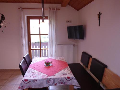 a dining room with a table and chairs and a window at Gillingerhof in Chamerau