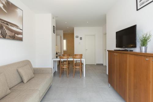 a living room with a couch and a table with chairs at Prestige Apartments by Quokka 360 - spacious flats with terraces in Lugano