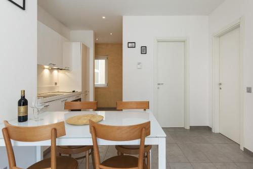a kitchen and dining room with a white table and chairs at Prestige Apartments by Quokka 360 - spacious flats with terraces in Lugano