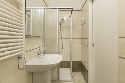 a white bathroom with a sink and a shower at Prestige Apartments by Quokka 360 - spacious flats with terraces in Lugano