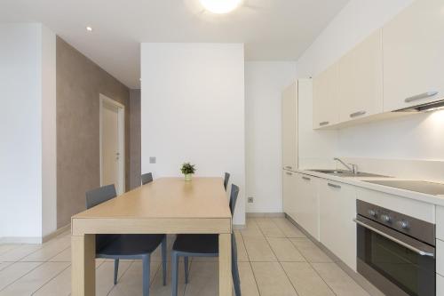 a kitchen with a wooden table and chairs at Prestige Apartments by Quokka 360 - spacious flats with terraces in Lugano