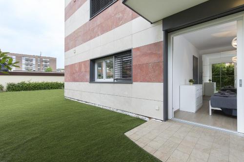 a house with a green lawn in the backyard at Roggia Apartments by Quokka 360 - central flats with parking space in Lugano