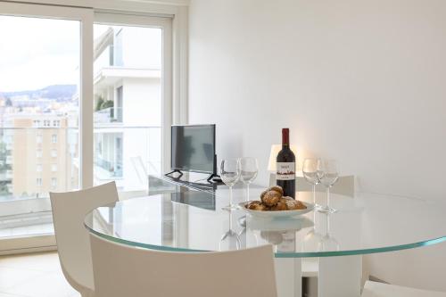 a dining room with a glass table with a bottle of wine at Prestige Apartments by Quokka 360 - spacious flats with terraces in Lugano