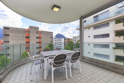 a patio with a table and chairs on a balcony at Prestige Apartments by Quokka 360 - spacious flats with terraces in Lugano