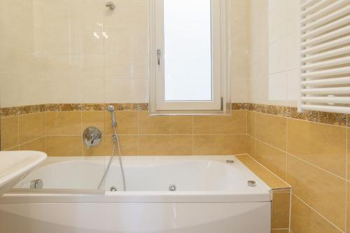 a white bath tub in a bathroom with a window at Prestige Apartments by Quokka 360 - spacious flats with terraces in Lugano