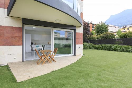 a patio with a table and chairs on a lawn at Roggia Apartments by Quokka 360 - central flats with parking space in Lugano