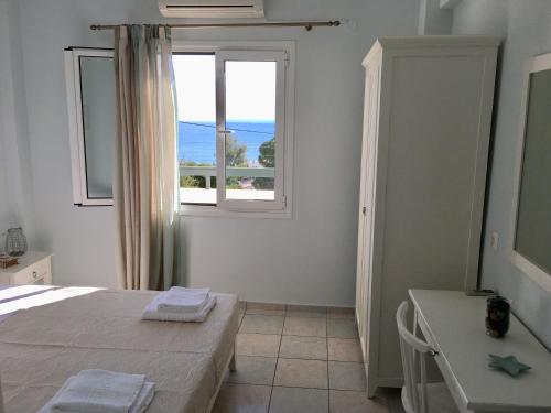 a bedroom with a bed and a window and a table at Liofoto Sea View Apartments in Stalida