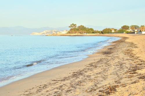 a beach with footprints in the sand and the water at Residence Mar Mediterraneo in Quartu SantʼElena