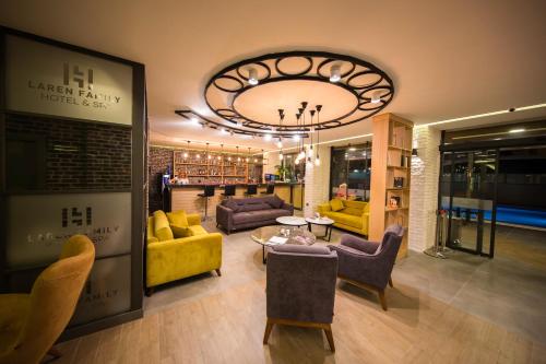 a living room with yellow furniture and a chandelier at Laren Family Hotel & Spa - Boutique Class in Antalya