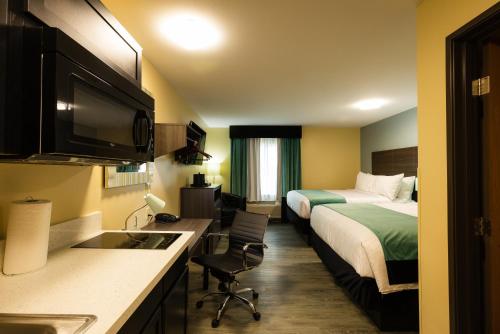 a hotel room with two beds and a kitchen with a sink at Hawthorn Suites by Wyndham St. Robert/Ft. Leonard Wood in Saint Robert