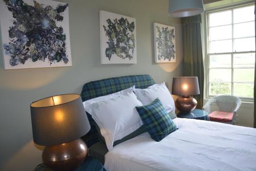 a bedroom with a bed with two lamps and a couch at Scaurbridge House in Thornhill