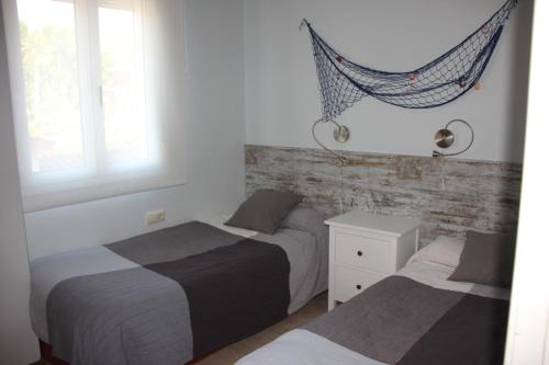 1 dormitorio con 2 camas y hamaca. en Apartamentos Caru, en Castelldefels