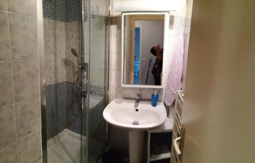 een badkamer met wastafel en douche met spiegel bij APARTAMENTO HENDAYA Playa-wifi-parking in Hendaye