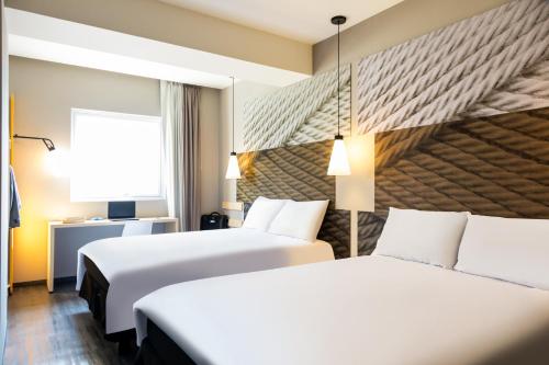 a hotel room with two beds and a window at Ibis Mexico Tlalnepantla in Mexico City