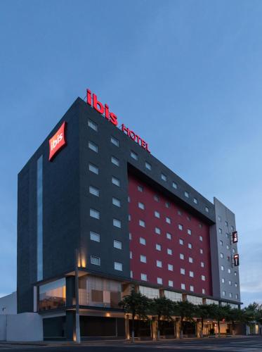 a hotel with a red sign on top of it at Ibis Mexico Tlalnepantla in Mexico City