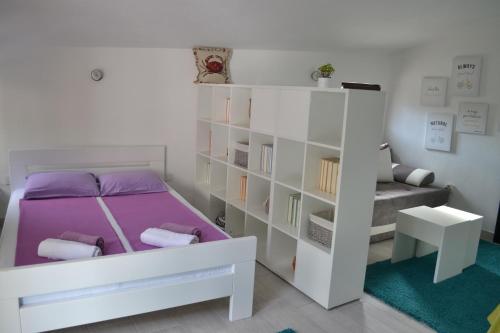 a bedroom with a bed and a book shelf at Apartments Niković in Risan