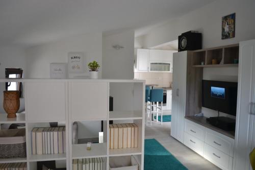 a living room with white cabinets and a television at Apartments Niković in Risan