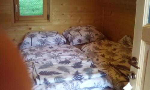 um pequeno quarto com uma cama e duas almofadas em farmglamping Planika - Encijan em Hraše