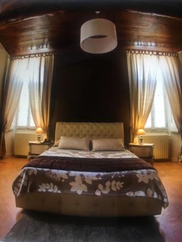 a bedroom with a large bed and two windows at Villa L' Antico Torchio in Dormelletto