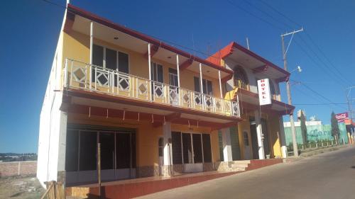 a yellow building with a balcony on a street at Hotel Don Fer in Chignahuapan