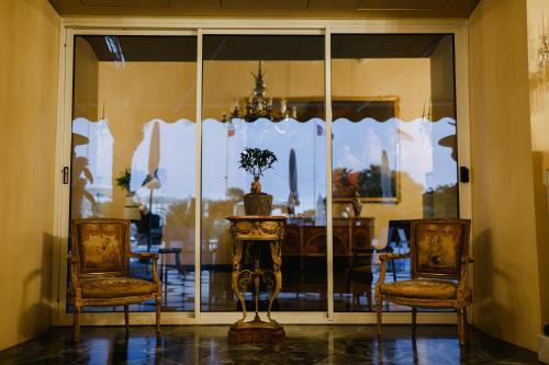 a dining room with a table and two chairs and a window at Grand Hotel Del Mare Resort & Spa in Bordighera