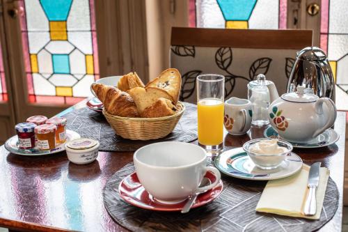 a table with a basket of bread and a cup of orange juice at Hôtel Terminus in Cahors