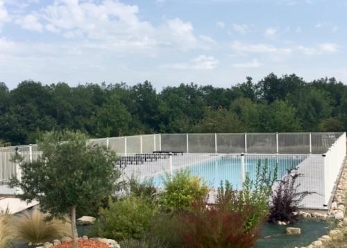 a swimming pool with a fence and trees at Chambres d'Hôtes Lieu Dit Cruzel in Moissac