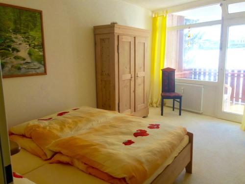 ein Schlafzimmer mit einem Bett mit roten Blumen darauf in der Unterkunft Koenigs Appartement mit Pool in Schluchsee