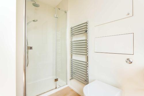 a bathroom with a shower and a toilet at Veeve - Timeless Family Home in London