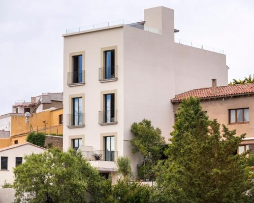 a white building with trees in front of it at Alta House Begur in Begur