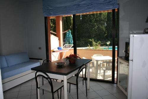 a kitchen with a table and chairs and a window at Verdemare Sardegna Uno in Villasimius