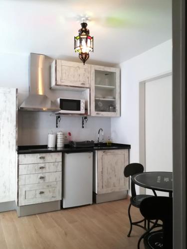 a kitchen with white cabinets and a table at Casinhas da Ajuda nº 29 in Lisbon