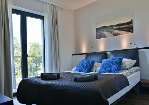 - une chambre avec un grand lit et des oreillers bleus dans l'établissement Siedlisko Kłodno, à Sulęczyno