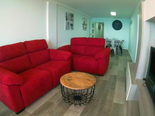 ベニドルムにあるMarqués de Comillas IIのリビングルーム(赤いソファ2台、テーブル付)