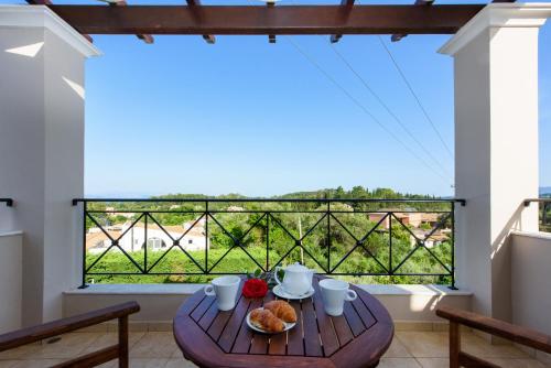 a table with food on a balcony with a view at Tesori Dassia Villas in Dassia