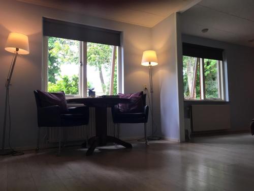 ネスにあるBrissagoのテーブルと椅子2脚、窓2つが備わる客室です。
