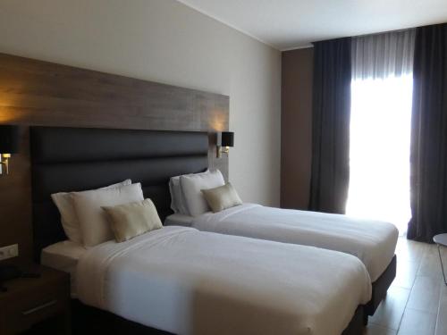 Un pat sau paturi într-o cameră la Le Zenith Hotel Oran
