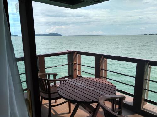a table and chairs sitting on a balcony overlooking the ocean at Langkawi Lagoon Resort Water Chalet in Pantai Cenang
